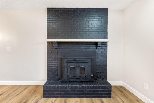 3998 Scioto Darby Creek Rd, Hilliard, OH 43026 - detailed view of wood finished floors, baseboards, a textured ceiling, and a wood stove