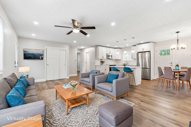 3998 Scioto Darby Creek Rd, Hilliard, OH 43026 - living area featuring a ceiling fan, light wood finished floors, recessed lighting, baseboards, and a chandelier