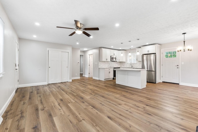 3998 Scioto Darby Creek Rd, Hilliard, OH 43026 - kitchen with appliances with stainless steel finishes, open floor plan, ceiling fan, light wood-style flooring, and a kitchen island