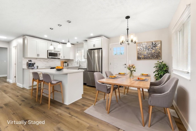 3998 Scioto Darby Creek Rd, Hilliard, OH 43026 - kitchen with stainless steel appliances, backsplash, a chandelier, a center island, and baseboards