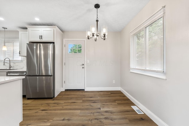 3998 Scioto Darby Creek Rd, Hilliard, OH 43026 - kitchen with freestanding refrigerator, white cabinets, a chandelier, dark wood-style floors, and hanging light fixtures