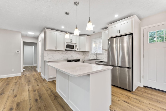 3998 Scioto Darby Creek Rd, Hilliard, OH 43026 - kitchen with appliances with stainless steel finishes, tasteful backsplash, light wood-type flooring, recessed lighting, and a textured ceiling