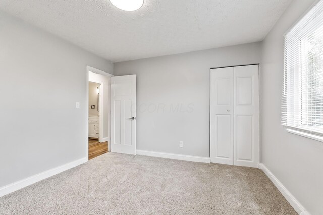 3998 Scioto Darby Creek Rd, Hilliard, OH 43026 - unfurnished bedroom featuring carpet, a closet, baseboards, and a textured ceiling