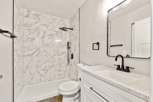 3998 Scioto Darby Creek Rd, Hilliard, OH 43026 - bathroom with toilet, vanity, a tile shower, wood finished floors, and a textured ceiling
