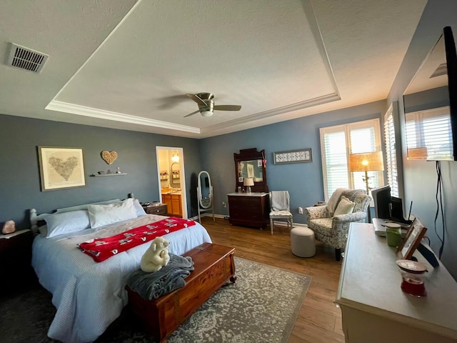 6231 Red Glare Dr Unit 287, Galloway, OH 43119 - bedroom with a tray ceiling, light wood-style floors, connected bathroom, and ceiling fan