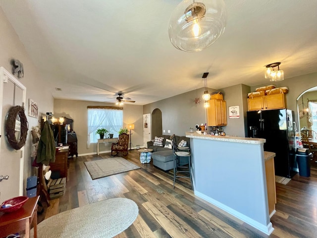 6231 Red Glare Dr Unit 287, Galloway, OH 43119 - kitchen featuring arched walkways, black fridge, dark wood-style flooring, and a peninsula