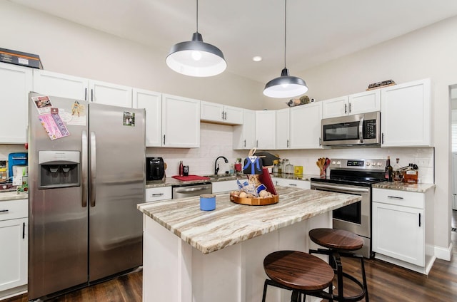 626-628 Wilson Ave, Columbus, OH 43205 - kitchen featuring appliances with stainless steel finishes, dark wood finished floors, backsplash, a kitchen bar, and recessed lighting