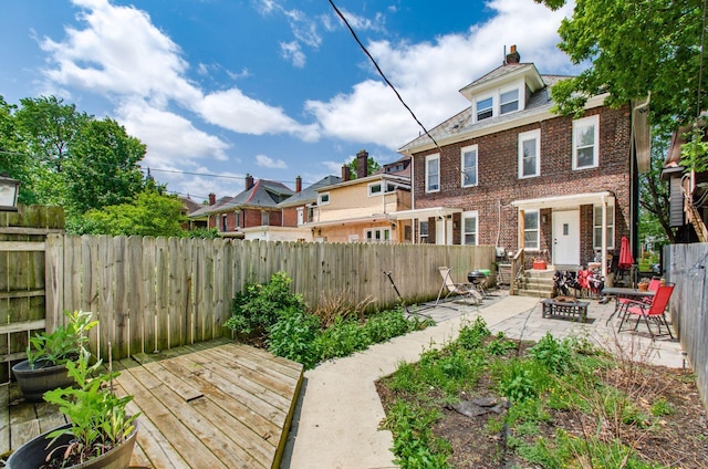 626-628 Wilson Ave, Columbus, OH 43205 - back of property with a fenced backyard, brick siding, a patio, and a wooden deck