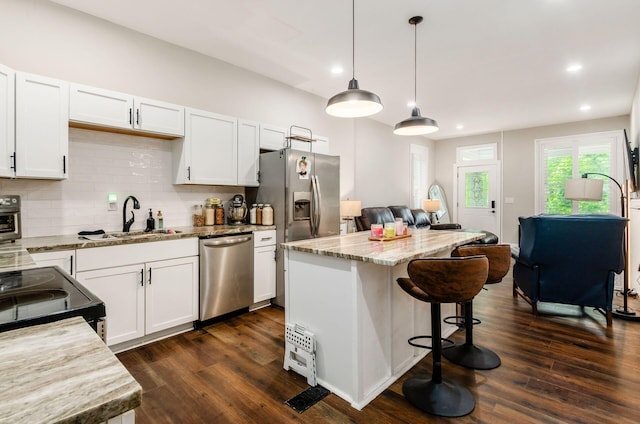 626-628 Wilson Ave, Columbus, OH 43205 - kitchen with stainless steel appliances, a sink, open floor plan, white cabinets, and tasteful backsplash