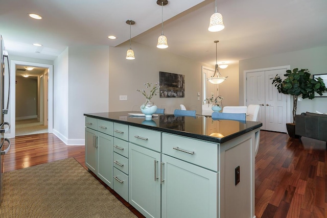 873 S Pearl St, Columbus, OH 43206 - kitchen featuring dark countertops, dark wood-type flooring, a center island, pendant lighting, and baseboards