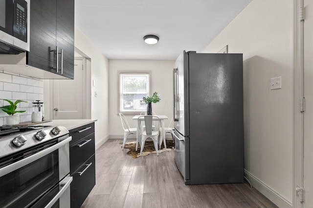 3091 Azelda St, Columbus, OH 43224 - kitchen with stainless steel appliances, tasteful backsplash, dark cabinets, and wood finished floors