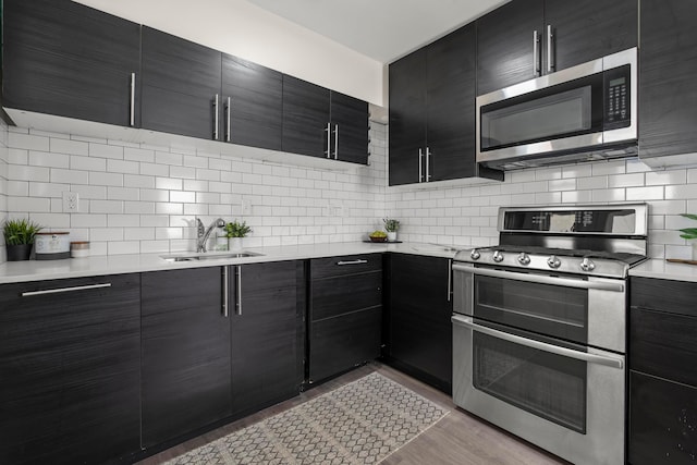 3091 Azelda St, Columbus, OH 43224 - kitchen with stainless steel appliances, a sink, modern cabinets, light countertops, and dark cabinets