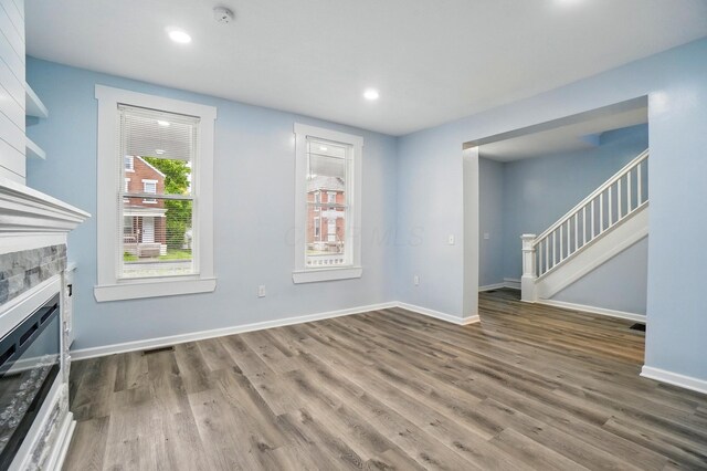 517 S Champion Ave, Columbus, OH 43205 - unfurnished living room with wood finished floors, a fireplace, baseboards, recessed lighting, and stairway