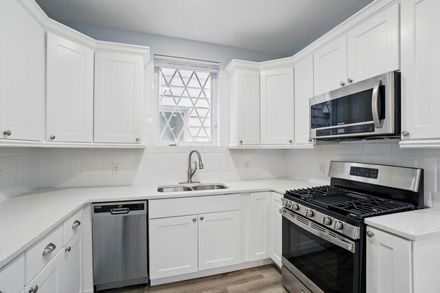 517 S Champion Ave, Columbus, OH 43205 - kitchen featuring stainless steel appliances, a sink, white cabinets, and tasteful backsplash