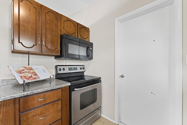 4930 Carbondale Dr, Columbus, OH 43232 - kitchen with black microwave, stainless steel range with electric stovetop, and brown cabinetry