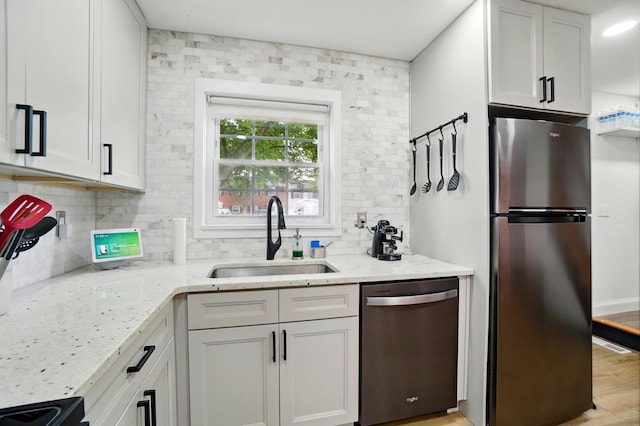 538 S Otterbein Ave Unit 2E, Westerville, OH 43081 - kitchen featuring dishwashing machine, freestanding refrigerator, a sink, backsplash, and light stone counters