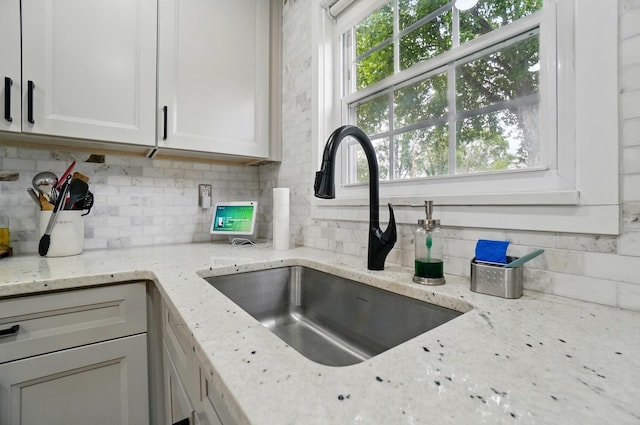 538 S Otterbein Ave Unit 2E, Westerville, OH 43081 - kitchen featuring a sink, decorative backsplash, white cabinetry, and light stone countertops