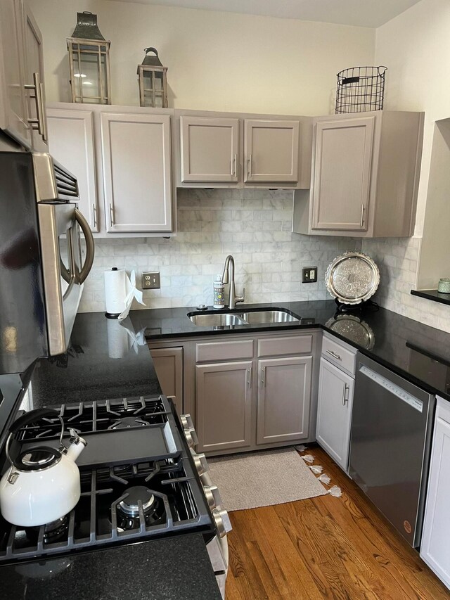 323 E Kossuth St, Columbus, OH 43206 - kitchen with a sink, appliances with stainless steel finishes, backsplash, and wood finished floors