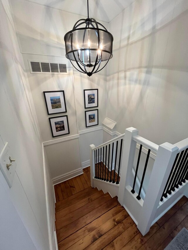 323 E Kossuth St, Columbus, OH 43206 - staircase featuring wood-type flooring and a chandelier