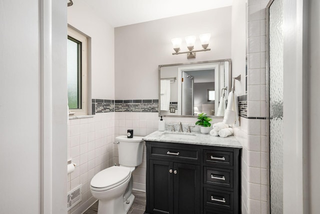 2105 Chardon Rd, Columbus, OH 43220 - full bath with tile walls, toilet, vanity, wainscoting, and a chandelier