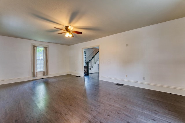 216 N St, Utica, OH 43080 - spare room with ceiling fan, dark wood finished floors, baseboards, and stairway