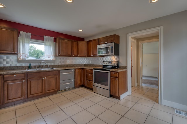 216 N St, Utica, OH 43080 - kitchen featuring stainless steel appliances, a sink, backsplash, brown cabinets, and recessed lighting