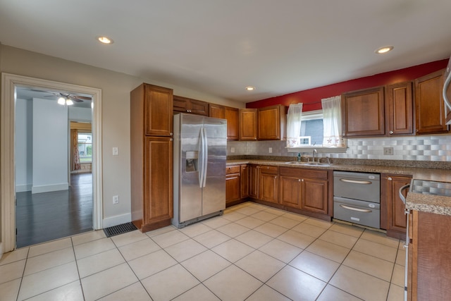 216 N St, Utica, OH 43080 - kitchen with appliances with stainless steel finishes, a sink, tasteful backsplash, brown cabinets, and light tile patterned flooring