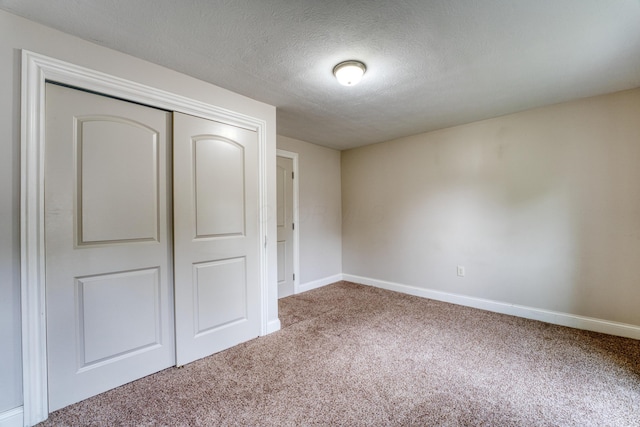 216 N St, Utica, OH 43080 - unfurnished bedroom featuring carpet, baseboards, a closet, and a textured ceiling