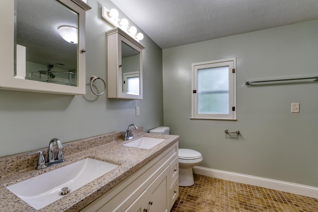 216 N St, Utica, OH 43080 - full bath with toilet, double vanity, baseboards, a textured ceiling, and tile patterned flooring