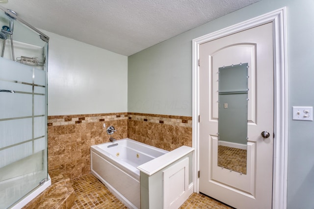 216 N St, Utica, OH 43080 - full bath featuring tile walls, a tub with jets, wainscoting, a textured ceiling, and tile patterned floors