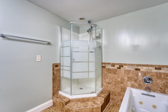 216 N St, Utica, OH 43080 - full bathroom with a shower stall, a tub with jets, tile patterned floors, tile walls, and a textured ceiling