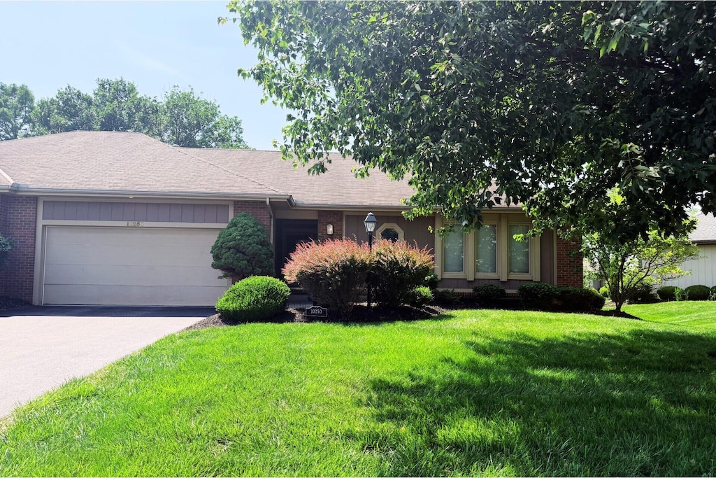 10250 Braemar Dr, Powell, OH 43065 - ranch-style home featuring brick siding, an attached garage, a front yard, and driveway