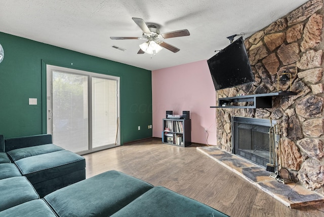 5722 Jousting Ln Unit B, Columbus, OH 43231 - living area featuring ceiling fan, wood finished floors, a stone fireplace, and a textured ceiling