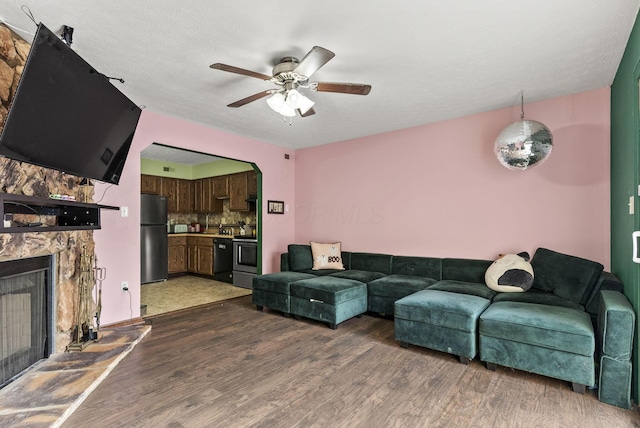 5722 Jousting Ln Unit B, Columbus, OH 43231 - living room featuring dark wood-type flooring, a ceiling fan, and a stone fireplace