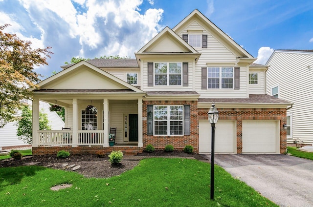 5673 Sugarwood Dr, New Albany, OH 43054 - view of front of home with a garage, covered porch, asphalt driveway, brick siding, and a front lawn
