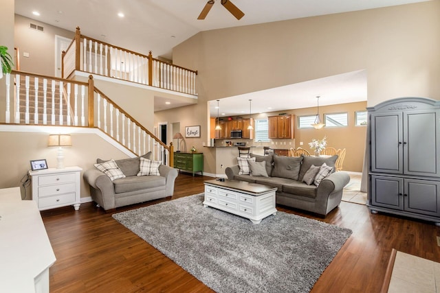 5673 Sugarwood Dr, New Albany, OH 43054 - living room featuring stairs, a ceiling fan, dark wood-type flooring, baseboards, and high vaulted ceiling