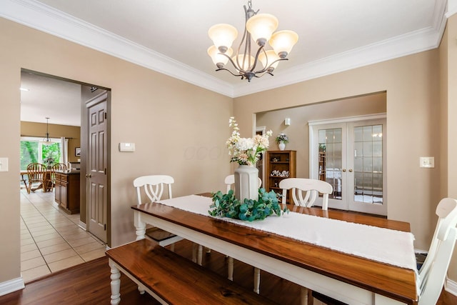 5673 Sugarwood Dr, New Albany, OH 43054 - dining area with a chandelier, wood finished floors, crown molding, french doors, and baseboards