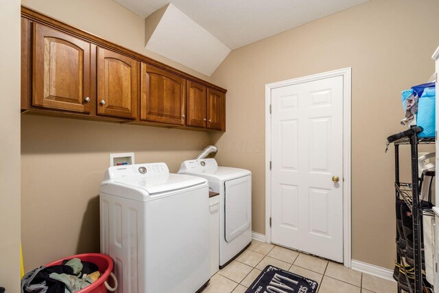 5673 Sugarwood Dr, New Albany, OH 43054 - laundry room with washing machine and clothes dryer, cabinet space, light tile patterned floors, and baseboards
