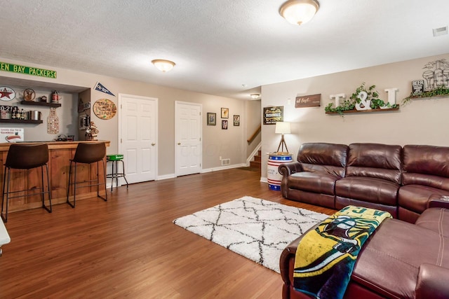 5673 Sugarwood Dr, New Albany, OH 43054 - living area with bar, stairs, wood finished floors, and baseboards
