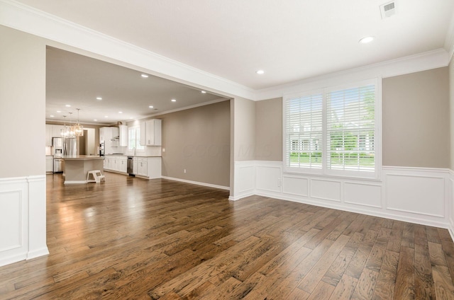 7839 Eastcross Dr, New Albany, OH 43054 - unfurnished living room featuring crown molding, dark wood-style flooring, wainscoting, a chandelier, and recessed lighting