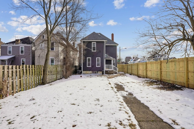 1598 Harvard Ave, Columbus, OH 43203 - snow covered rear of property featuring a chimney and a fenced backyard