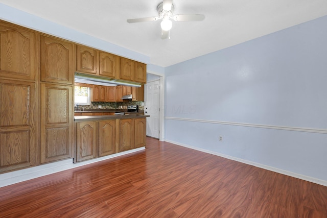 883 Mcnaughten Rd, Columbus, OH 43213 - kitchen with stainless steel range with electric stovetop, dark countertops, dark wood-type flooring, ceiling fan, and brown cabinetry
