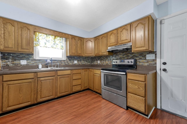 883 Mcnaughten Rd, Columbus, OH 43213 - kitchen with under cabinet range hood, stainless steel electric range, backsplash, and wood finished floors