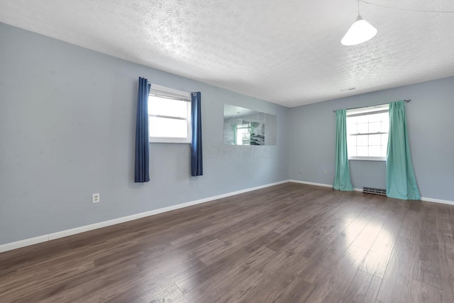 883 Mcnaughten Rd, Columbus, OH 43213 - unfurnished room featuring plenty of natural light, a textured ceiling, and dark wood-style flooring
