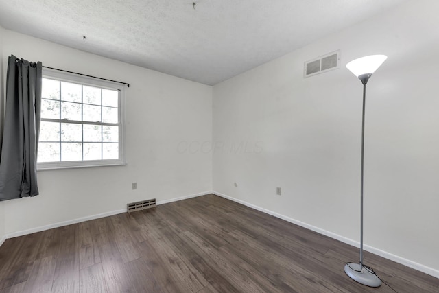 883 Mcnaughten Rd, Columbus, OH 43213 - spare room featuring dark wood-style floors and a textured ceiling