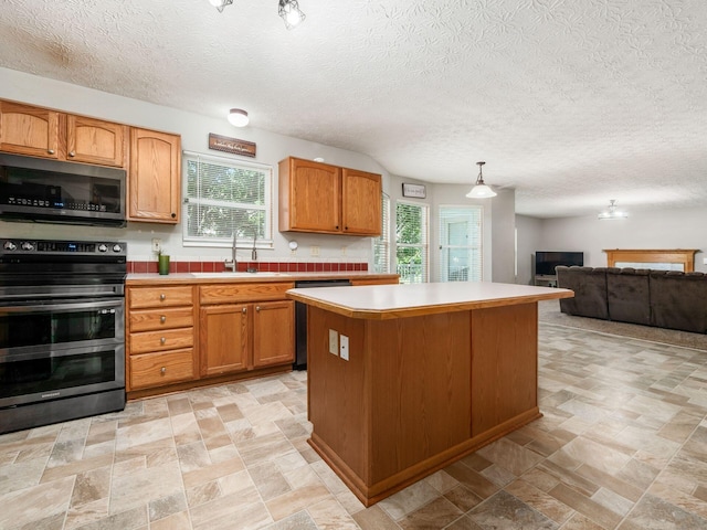 263 Timber Hearth Ct, Newark, OH 43055 - kitchen featuring stainless steel appliances, a center island, light countertops, open floor plan, and light stone finish flooring