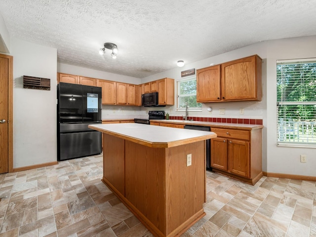 263 Timber Hearth Ct, Newark, OH 43055 - kitchen featuring black appliances, a kitchen island, light countertops, and light stone finish flooring