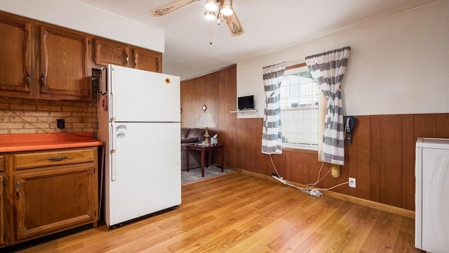 524 Ridgefield Rd, Newark, OH 43055 - kitchen featuring freestanding refrigerator, washer / dryer, light wood-type flooring, wooden walls, and brown cabinets
