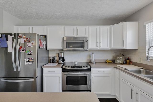 226 Purple Finch Loop, Pataskala, OH 43062 - kitchen featuring stainless steel appliances, a sink, white cabinetry, light countertops, and a textured ceiling