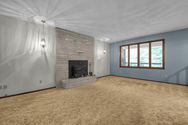 363 Carroll Eastern Rd NW, Baltimore, OH 43105 - unfurnished living room with a wood stove, carpet flooring, and baseboards